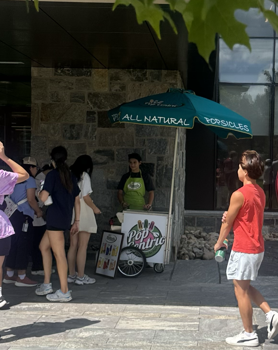 PopCentric cart serving students outdoors under a teal umbrella